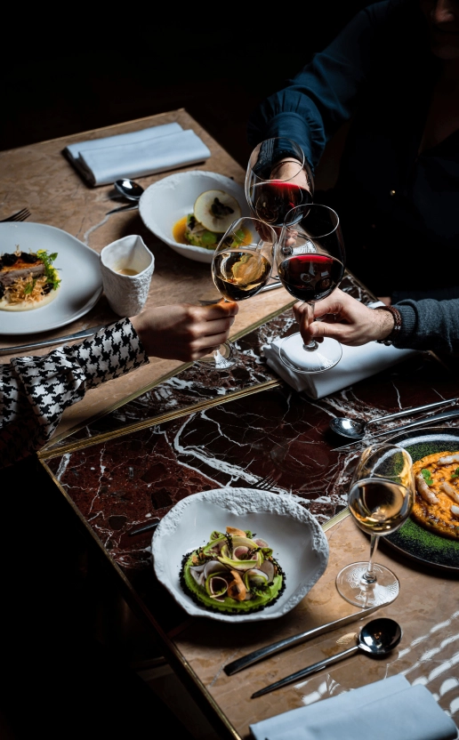 Teambuilding dans le noir avec des collaborateurs trinquant autour de plats raffinés