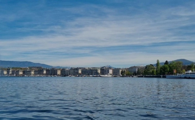 Vue panoramique du Jet d’Eau de Genève sur le lac Léman, avec la ville et les montagnes en arrière-plan
