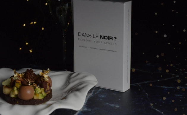 Dessert gourmand et coffret cadeau Dans le Noir ? sur fond sombre et festif, illustrant une expérience sensorielle unique à offrir pour Noël.