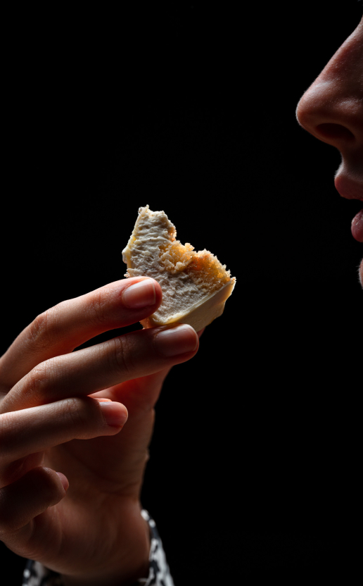 Hand holding a piece of dessert during a tasting workshop at the Dans le Noir ? restaurant.