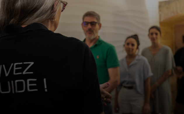 Un guide de Dans le Noir ? accueille un groupe de clients avant de les accompagner dans l’expérience sensorielle.