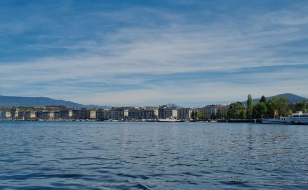 Vue panoramique du Jet d’Eau de Genève sur le lac Léman, avec la ville et les montagnes en arrière-plan